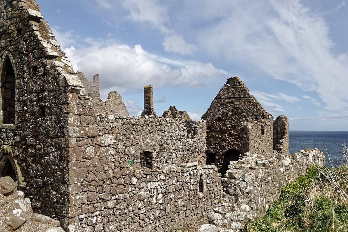 The roofless stone buildings of Dunnottar Castle with the North Sea beyond