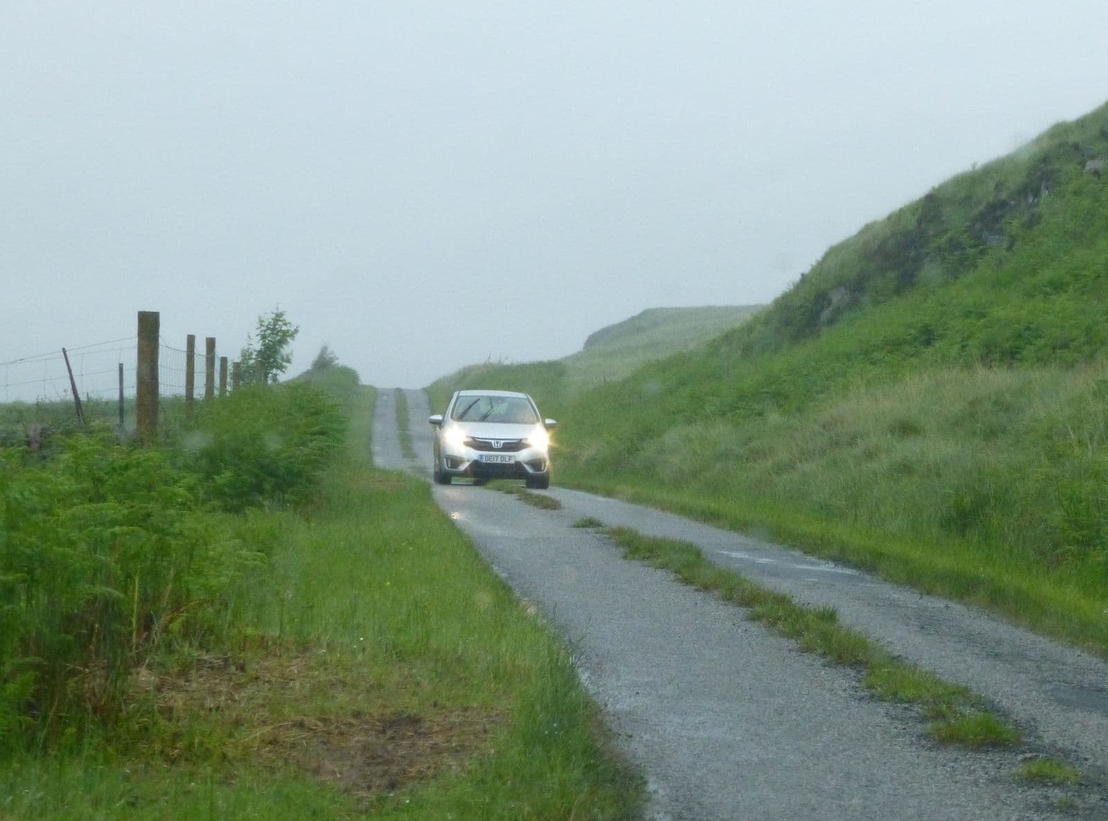 A car pulled into a passing place on a single-track Highland road