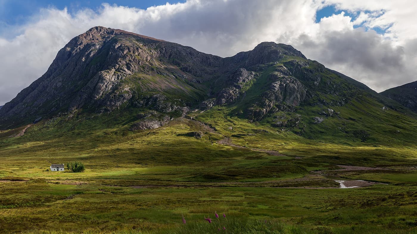 The pyramid of Buachaille Etive Mòr rising above a white cottage on the moor