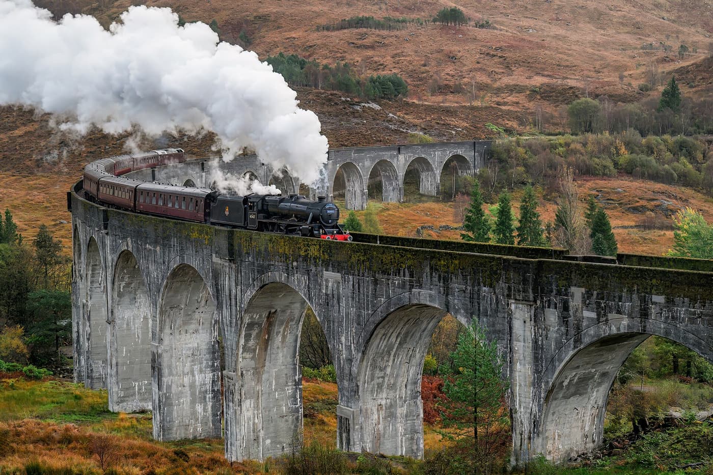 The Jacobite steam train crossing the curved Glenfinnan Viaduct