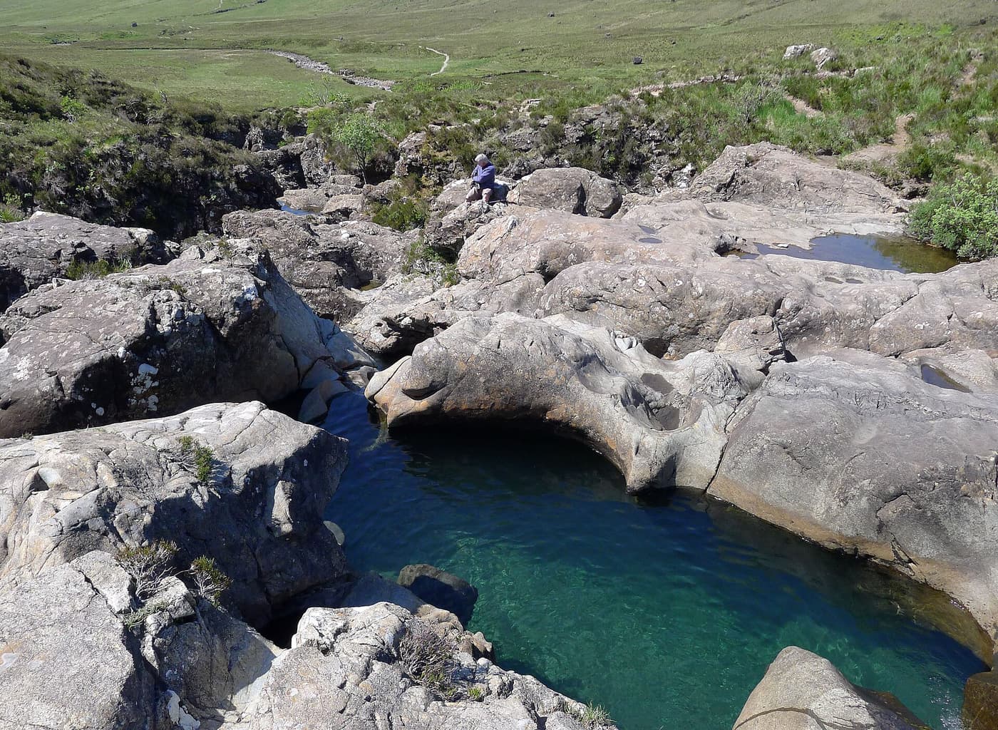 A clear blue-green pool among rocks at the Fairy Pools in Glen Brittle