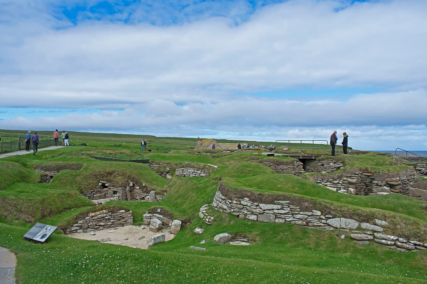 The stone-walled Neolithic houses of Skara Brae sunk into the turf beside the sea