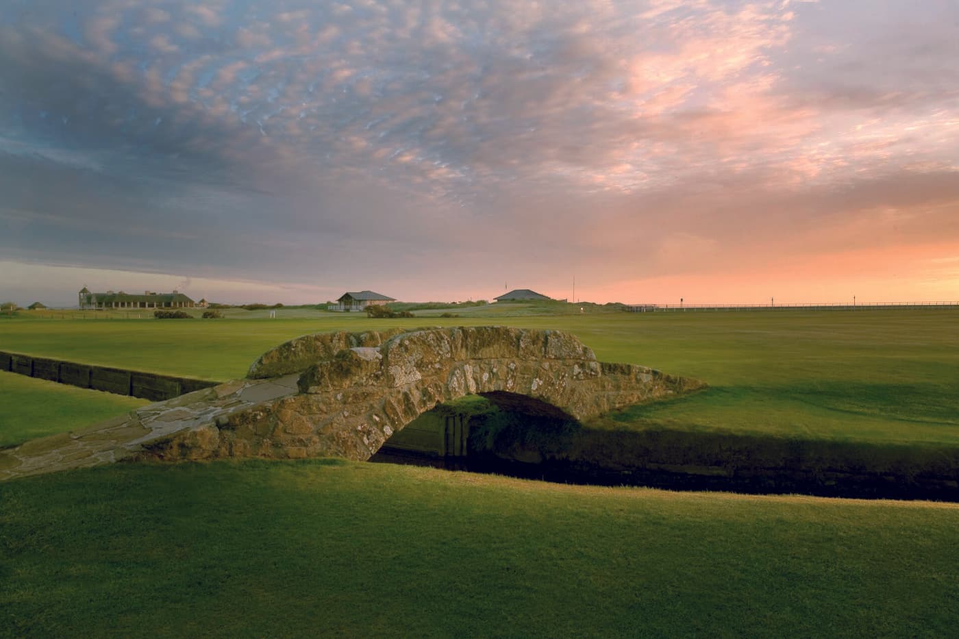 The small stone Swilcan Bridge on the Old Course at St Andrews at sunset