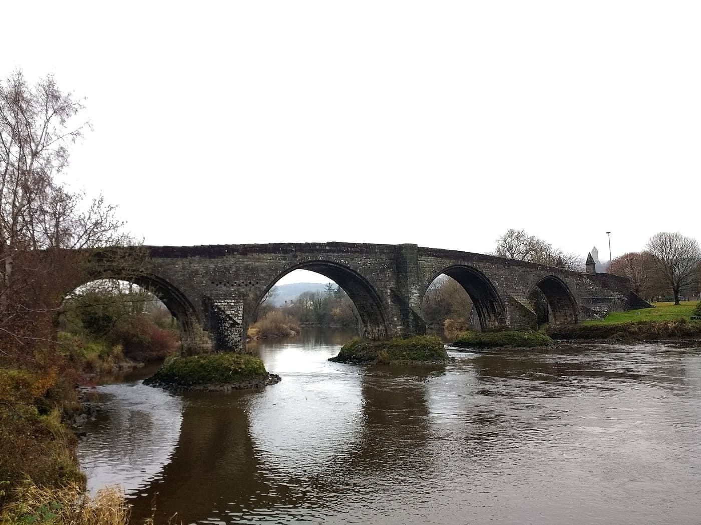 The medieval stone arches of Stirling Old Bridge over the River Forth